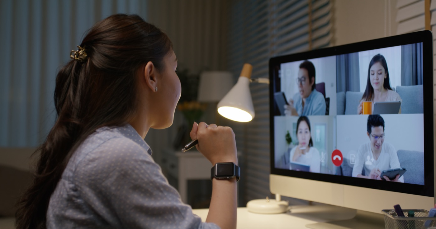 Team member on an evening video call at a warmly lit desk